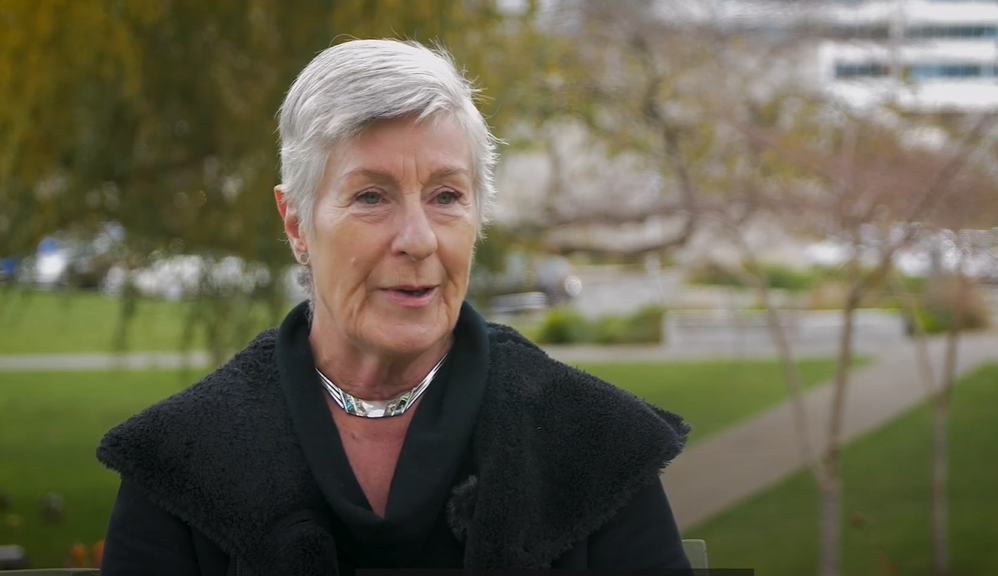 Older woman outside in a park speaking