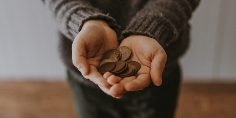 Person with hands outstretched holding coins