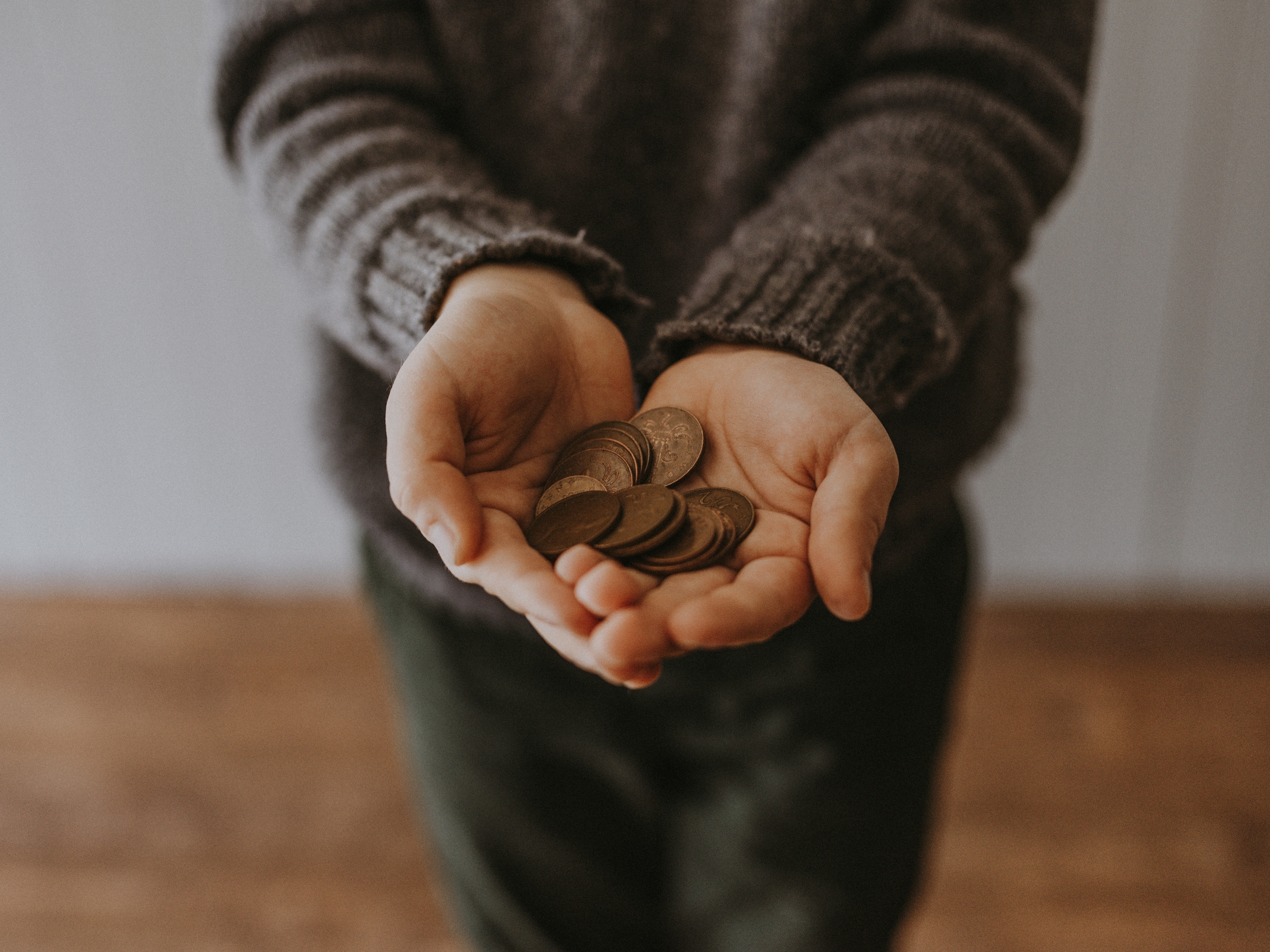 Person with hands outstretched holding coins