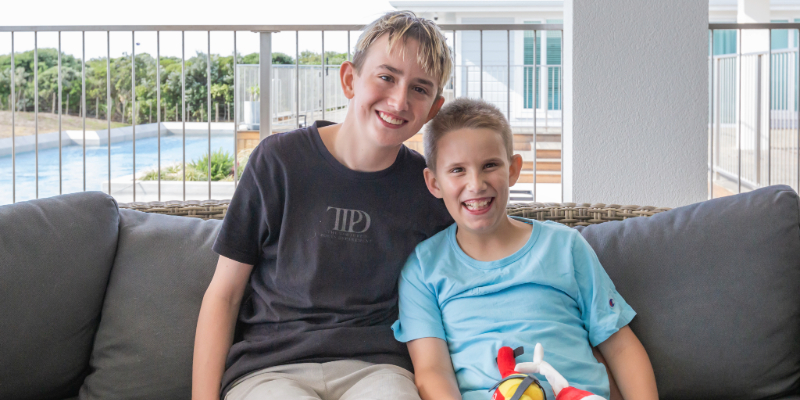Jason sitting on a couch with his brother.
