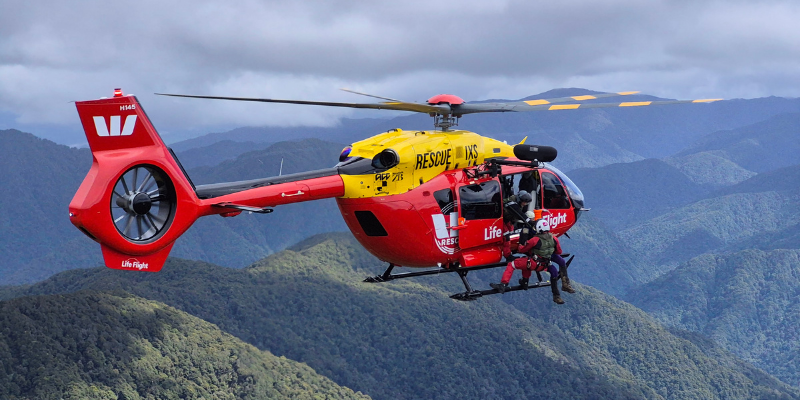 The Westpac Chopper hovering in the Tararua Ranges as Andrew is brought onboard by Critical Care Paramedic James.